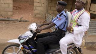 Police wey carry person for bike