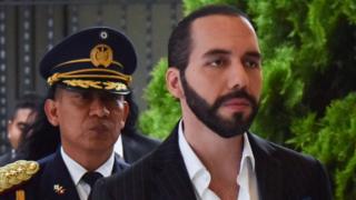 Nayib Bukele y un funcionario de seguridad detrás