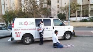 رجلان يصليان، يهودي ومسلم بقرب سيارة إسعاف
