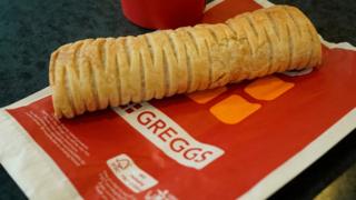 Рулет с веганской сосиской Greggs на бумажном пакете