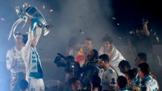 لاعبون من ريال مدريد يرفعون كأس البطولة