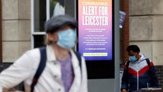 An NHS alert message is seen on a street in Leicester