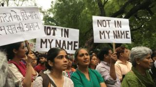People protesting against cow vigilante groups with signs that read "not in my name"