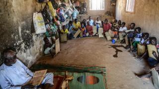 Kids from different district of Nigeria learn to read and memorize the verses of the Quran written with ink on wooden panels at a boarding school in Jimeta, Nigeria on December 08, 2014.