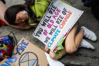 Activists play dead on the floor with banners