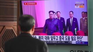 Homem assiste a programa noticioso com imagens de Kim Jong-un