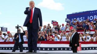 US President Donald Trump gestures in front of supporters at Basler Flight Service in Oshkosh, Wisconsin, US.