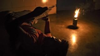 hombre lee a la luz de un mechero