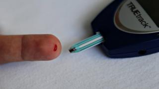 Пациент-диабетик измеряет уровень глюкозы в крови с помощью инвазивного глюкометра