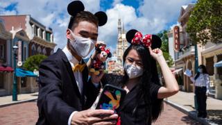 Visitors dressed in costumes take a selfie at Hong Kong's Disneyland - 18 June 2020