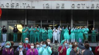 Health workers react as they take part in the nationwide daily gratitude applause to health workers in early April