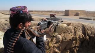 An Afghan Local Police (ALP) personnel keeps watch during an ongoing battle with Taliban militants in the Marjah district of Helmand Province on December 23