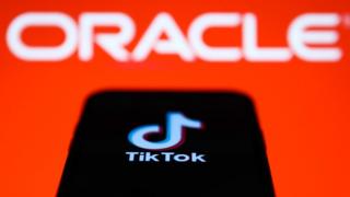 TikTok on mobile screen in front of Oracle logo