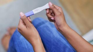 A woman's hands holding a pregnancy test