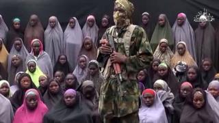 Boko Haram militanı, örgütün kaçırdığı kızların bazılarının önünde konuşuyor