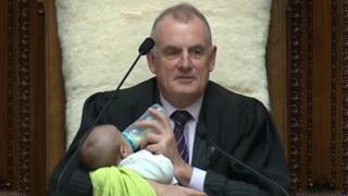 New Zealand's speaker Trevor Mallard cradles an MP's baby during a debate