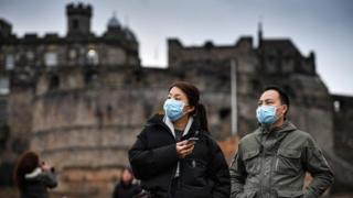 Туристы в масках в Эдинбургском замке