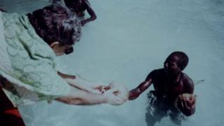 TN Pandit handing a coconut to a Sentinelese man