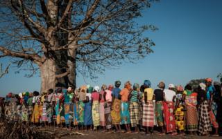 Women wait in a line to receive relief supplies in Estaquinha, Mozambique, on March 26, 2019.