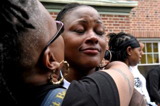 Blondina Bean is comforted while she is crying in memory of her son, George Phillips, victim of a gun homicide at the age of 19.