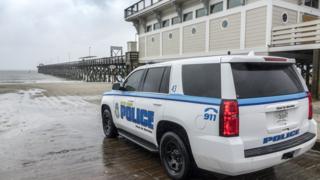 Police watch the entrance to the beach in Myrtle Beach, South Carolina