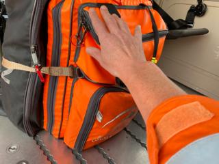 A hand reaches out for a medical backpack