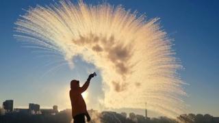 A man throwing a cup of hot water into the air