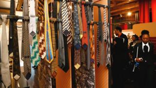 A woman walks past a collection of ties that belonged to South Africa's former President Nelson Mandela, Johannesburg, South Africa - Thursday 28 July 2018