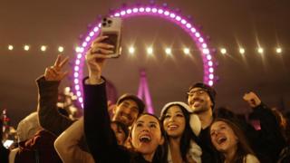 People taking selfies in front of London eye