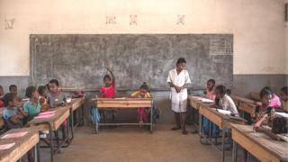 Olukọ kan duro, o n kọ awọn akẹkọọ