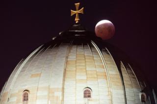 A view of the lunar eclipse above the St Elizabeth Church in Nuremberg, Germany