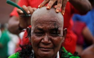 A supporter of Tamil Nadu Chief Minister Jayalalitha Jayaraman gets her head shaved near Jayalalitha's burial site in Chennai, India, December 7, 2016.