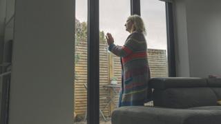 Woman looking out of her window