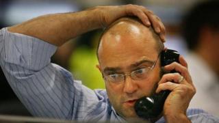 Homem fala ao telefone no trabalho