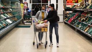 Compradores de Tesco con mascarillas