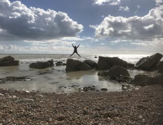 A women jumping off a rock