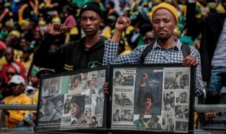 Mourners with raised clinched fists stand watching from the stands of the full 37,500-seater Orlando Stadium, in the township of Soweto, the funeral of the late anti-apartheid champion Winnie Madikizela-Mandela, concluding 10 days of national mourning on April 14, 2018, in Johannesburg. South Africans turned out in their thousands to bid final goodbyes to anti-apartheid icon and Nelson Mandela's former wife who was laid to rest with full state honours. Winnie Mandela, who died in Johannesburg aged 81 on April 2 after a long illness, has been celebrated for helping keep Nelson Mandela's dream of a non-racial South Africa alive while he was behind bars for 27 years.
