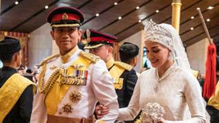 Prince Abdul Mateen (L) and Yang Mulia Anisha Rosnah walk down the aisle during their wedding reception at Istana Nurul Iman in Brunei's capital Bandar Seri Begawan