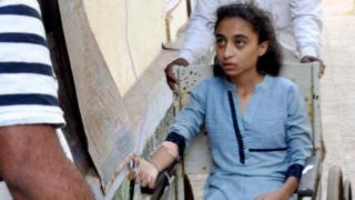 An Indian girl rescued from drowning sits in a wheelchair