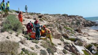 A rescue crew helps the woman after she broke her leg