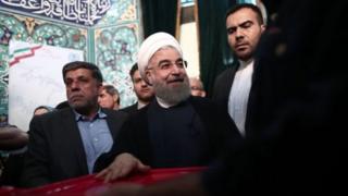 Mr Rouhani (na tsakiya) ya kada kuri'arsa a Tehran, babban birnin kasar.