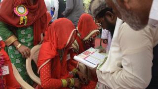 November 2016, an Indian bride listens as an officiator (2R) reads 'nikah ka certificate' or marriage certificate
