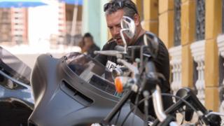 Ernesto Guevera , hijo del Che, con una moto y un puro.