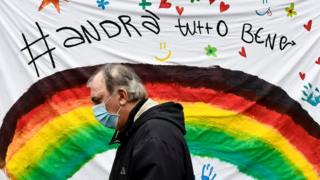 Un hombre pasa por delante de un cartel de apoyo en Italia