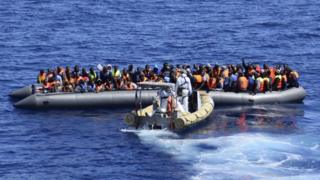 Мигранты сидят в лодке во время спасательной операции на кораблях итальянского флота у побережья Сицилии (11 апреля 2016 г.) (раздаточный материал итальянского флота)