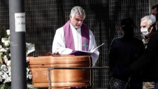 قس يصلي خلال مراسم جنازة في مدينة بنبلونة الإسبانية، ولم يُسمح إلا للأقارب بالحضور