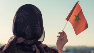 Une femme tenant le drapeau marocain
