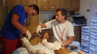 British medical students Tom Nash (left) and Ashley Davies replace a dressing