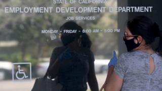 Woman outside closed California State Employment Development Department office due to coronavirus.