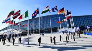 flags of the member states of nato waving outside nato's headquarters in brussels